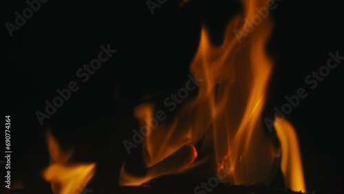 Une cheminée confortable et relaxante. Gros plan, flammes du feu. Feu de nuit, bûches sont en feu, étincelles volent. 4k, ralenti