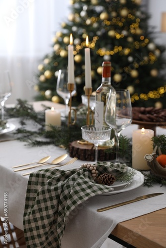Christmas table setting with festive decor and dishware in room © New Africa