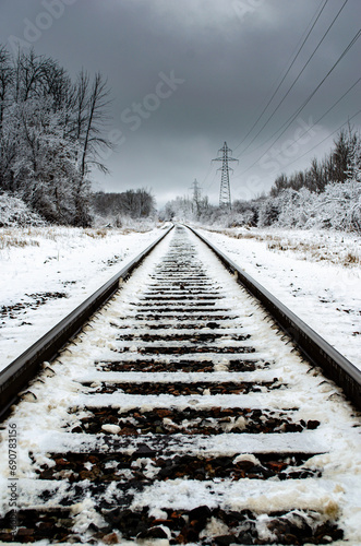 Railway tracks leading into the distance in a frozen landscape