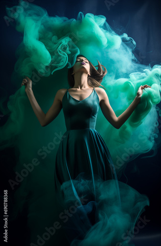 Beautiful girl dancing in green dress made of smoke. © Dragana