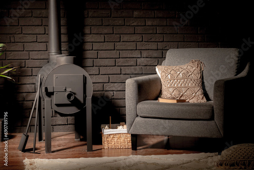 metal stove and chair on the background of a black brick wall