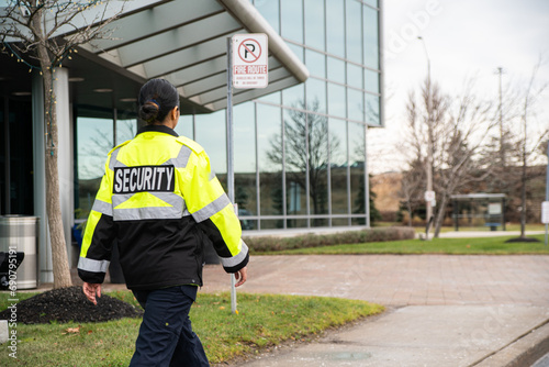 Security guard conducting access control, traffic control, and parking enforcement duties around a community building.
