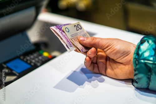 Woman paying in Polish zloty pln for a meal next to cash register inflation concept Polski ład photo