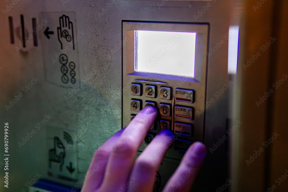 Obraz premium Person Imputing PIN into an ATM close up on hand