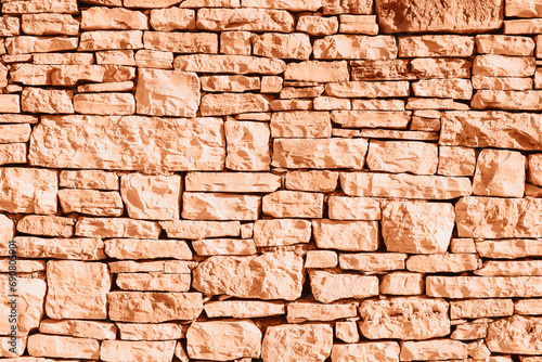 Old grunge stone masonry background  texture. Demonstrating color of the year 2024 Peach Fuzz
