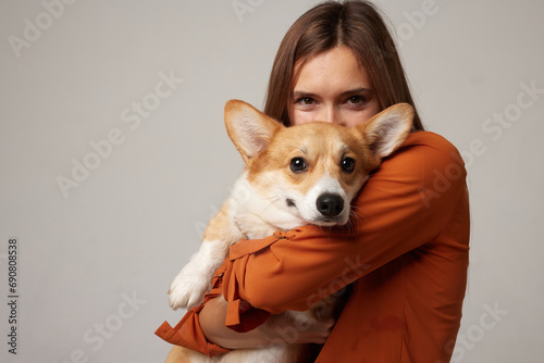 portrait of a girl and a corgi dog on a clean white background, love for animals photo