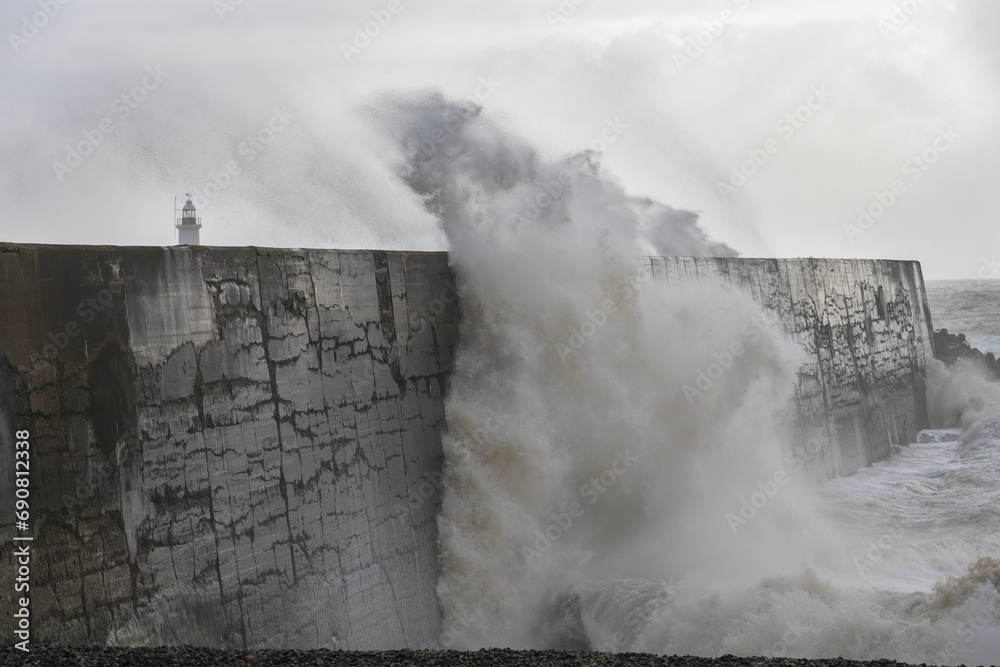 Fototapeta premium Stormy weather in Newhaven, East Sussex, England in autumn. View of the jetty and the lighthouse.