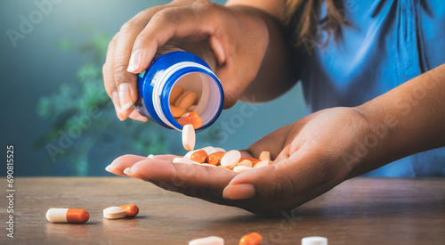 Woman's hand pours the medicine pills out of the bottle