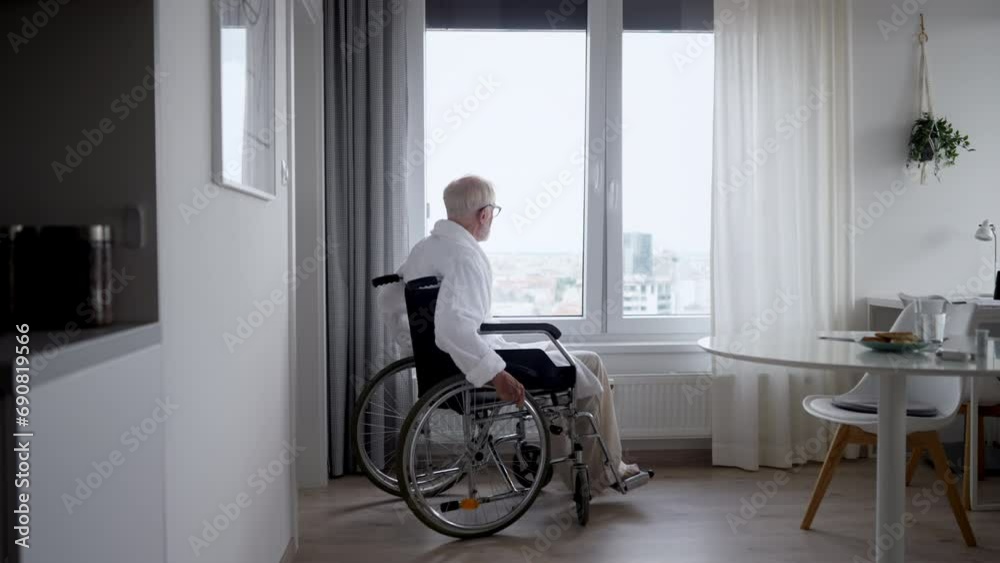 Senior man in a wheelchair spending time alone in his apartment. Senior man in a wheelchair spending time alone in his apartment.