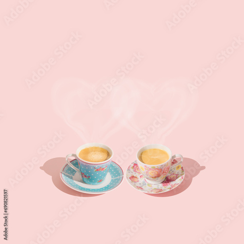 Creative layout with love hearts made of steaming coffee. Pink and blue cups of coffee on light pastel peachy pink background. Minimal love concept. Coffee aesthetic. Trendy coffee with love idea.