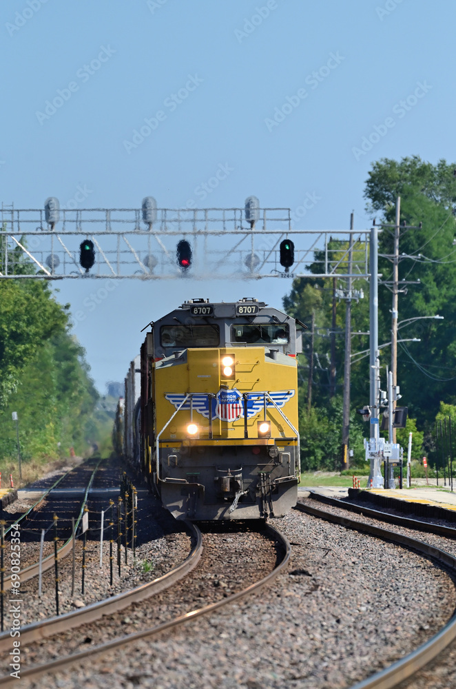 Multiple lead a Union Pacific freight train under a signal