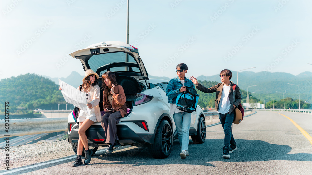Group of Asian generation z people friends sitting on car trunk looking beautiful nature of countryside. Man and woman friendship enjoy and fun outdoor lifestyle road trip on summer holiday vacation. - obrazy, fototapety, plakaty 