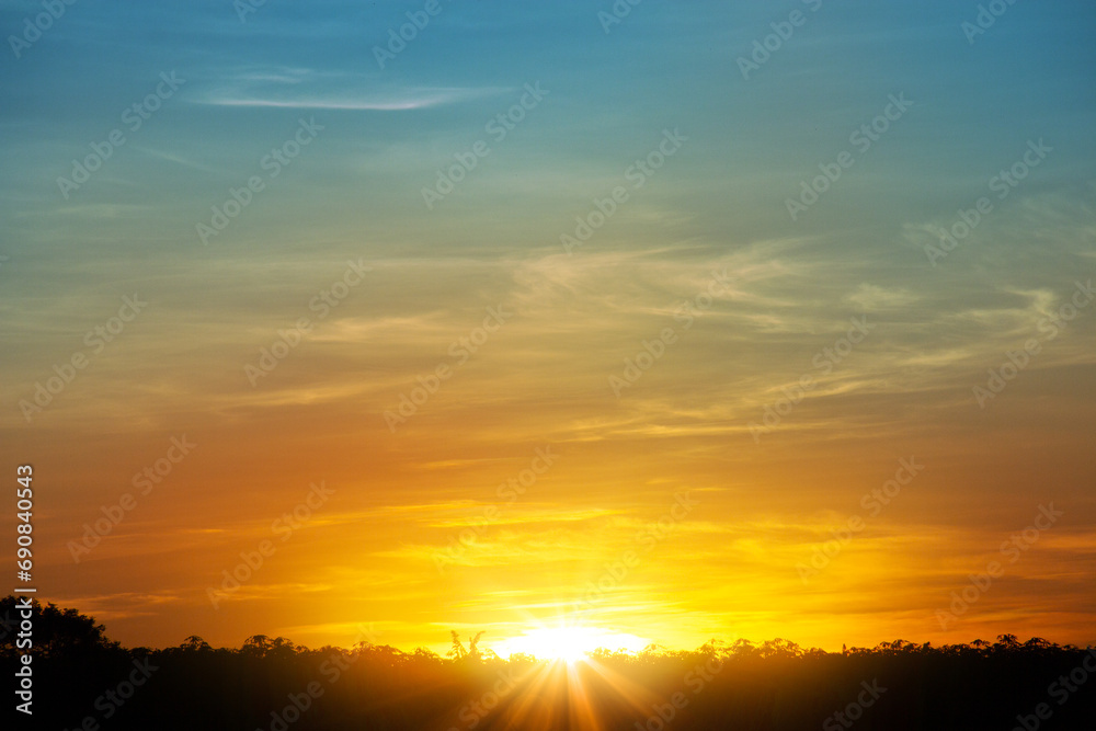 Sky is a gradient of orange and yellow with wispy clouds, creating a warm and inviting atmosphere