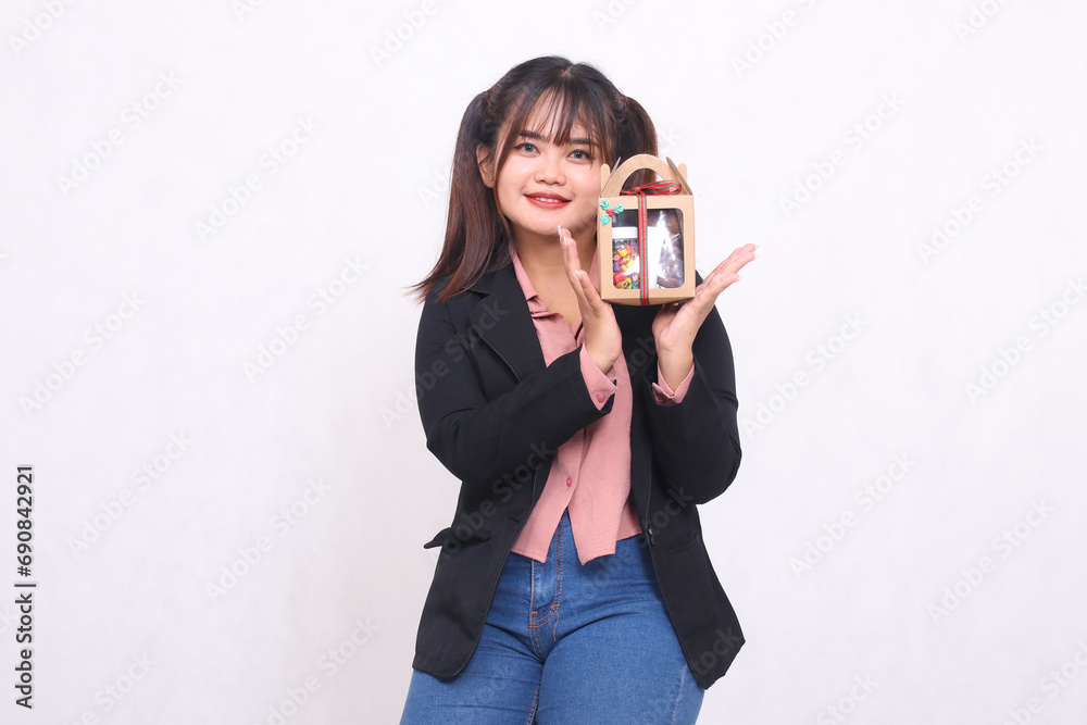 Beautiful Asian girl in her 20s smiling excitedly holding up Christmas gifts in the form of hampers looking at the camera on a white background for advertising materials, banners, billboards Beautiful Asian girl in her 20s smiling excitedly holding up Christmas gifts in the form of hampers looking at the camera on a white background for advertising materials, banners, billboards