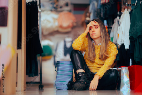 Tired Woman Feeling Overwhelmed During Shopping Spree. Unhappy exhausted customer resting on a store floor

 photo