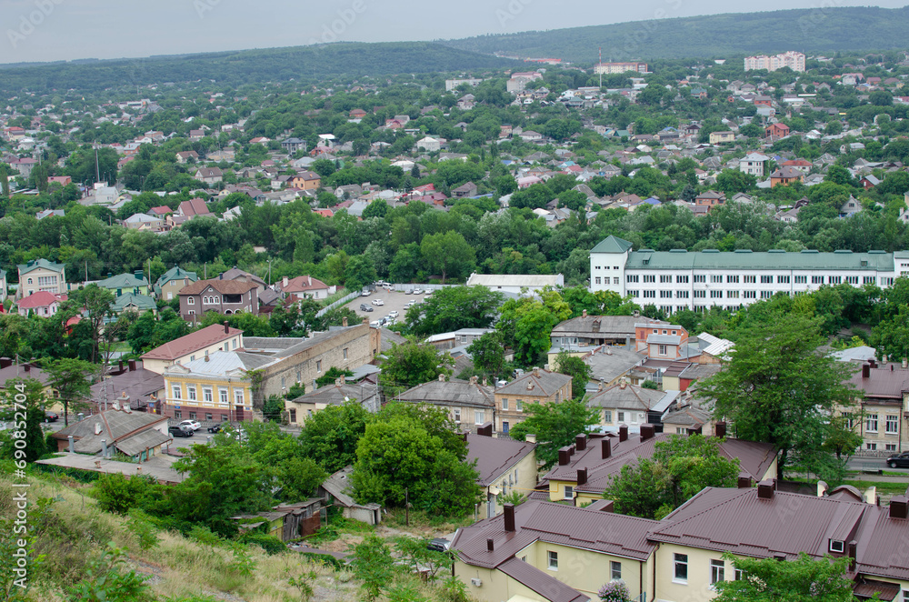 view of the city from the hill. top view of the roofs of houses and the road with cars.
