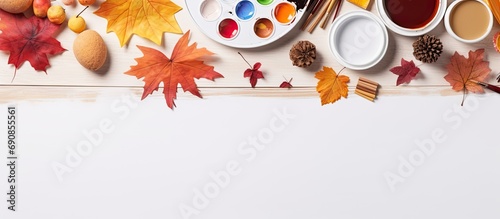 Autumn-themed crafts and paints are arranged on a white table, along with a disposable plate of colors. photo
