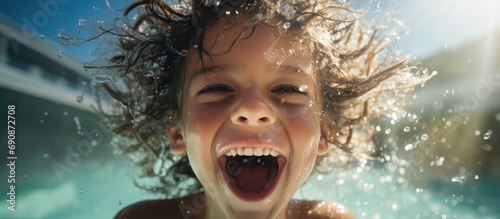 Joyful child splashing in the pool. © 2rogan