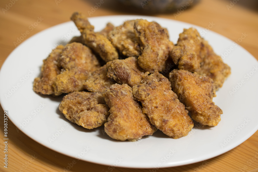 Delicious-looking fried chicken served on a white plate Delicious-looking fried chicken served on a white plate