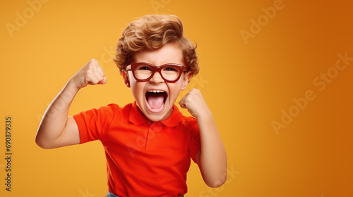Funny little power super hero kid showing muscles. Strength, confidence or defense from bullying. yellow background.