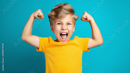 Funny little power super hero kid showing muscles. Strength, confidence or defense from bullying. blue background.