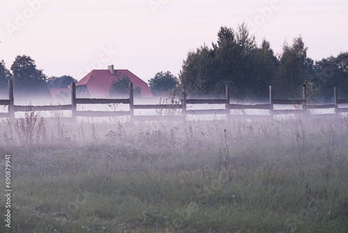 wooden fence, misty air, meadow, Latvia countryside, big bouders, pile of rocks photo