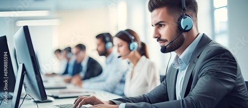 Call center workers with headphones are working at a modern office, how can I assist? photo