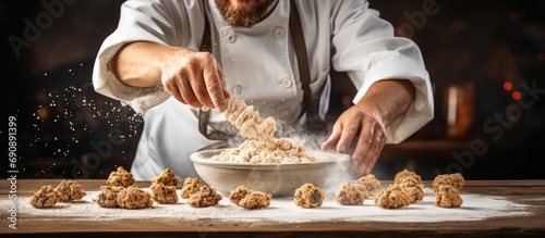 Baker chef adding cereal to oatmeal cookies. photo