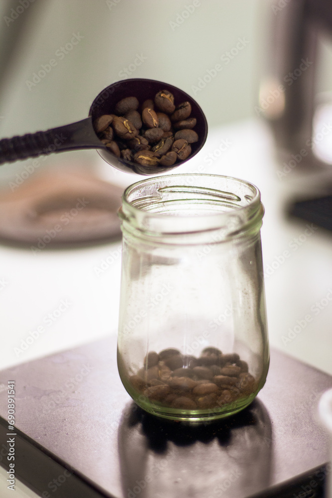 holding a tablespoon roasted coffee beans holding a tablespoon roasted coffee beans