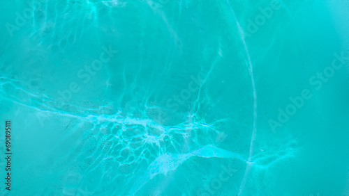 Blue wave abstracts or natural rippled water texture background Water waves in sunlight. Blurred transparent blue colored clear calm water surface texture with splashes and bubbles. 