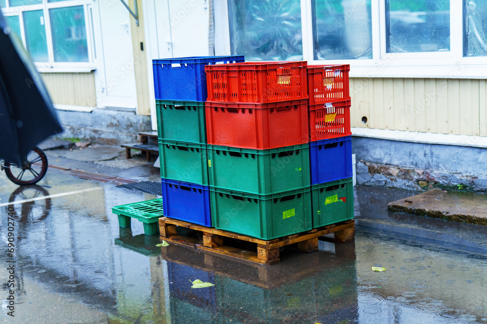 Colorful plastic crates stand on a wooden pallet Colorful plastic crates stand on a wooden pallet