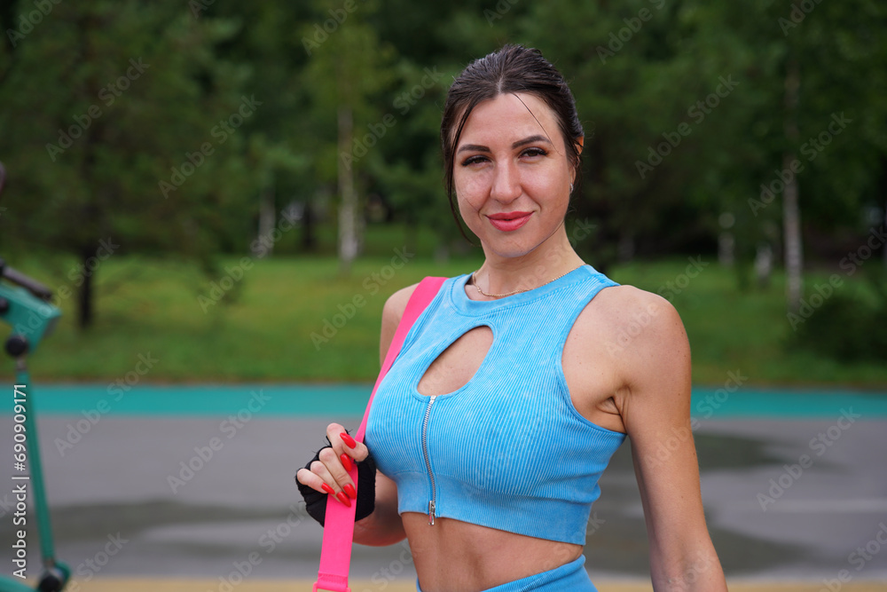 Fototapeta premium Young fit woman bodybuilder workout outdoors, training in the park at summer day, gain muscles. Fitness, bodybuilding concept. Open air gym.