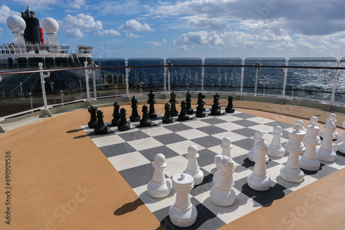 Open outdoor sun deck with large game of chess and figures onboard luxury cruiseship cruise ship ocean liner for entertainment and group game sports photo