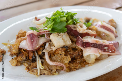 Asian delicious fried with mussels and octopus with eggs omelette add on bean sprout and mix chili sauce. Popular and delicious street food in Thailand. (Hoy Tod)