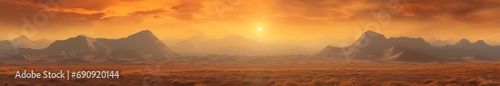 breathtaking beauty of sunrise in the desert. The sun rises over the deep blue mountains, bathing the panoramic landscape in warm light. Orange sky