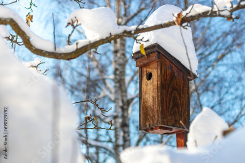 wooden birdhouse in winter, snow covered bird house © Roman