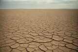 A landscape with dry cracked earth, a dried-up reservoir due to extreme drought, and natural conditions.