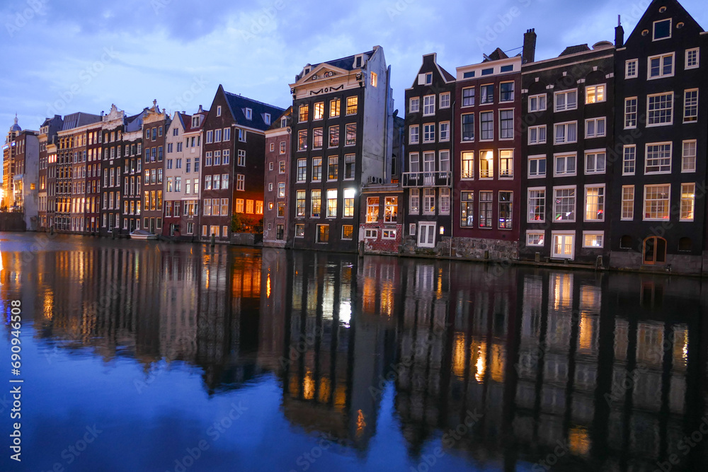 Amsterdam tiny houses mirroring in water canal, colourful sunset view, Amsterdam, Netherlands
