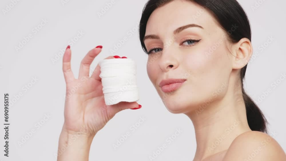 Charismatic, beautiful young woman using cosmetology cotton pads, isolated on the background. Advertising concept for clean skin, facial care and natural cosmetics. Charismatic, beautiful young woman using cosmetology cotton pads, isolated on the background. Advertising concept for clean skin, facial care and natural cosmetics.
