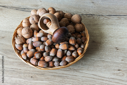 Rustic wooden plate with walnuts and walnuts on an oak table surface