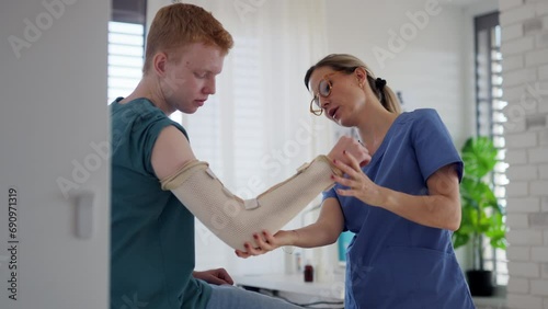 Doctor checking the orthopedic cast, brace on a teenage patient's broken arm. Teenage boy is healing a fracture after an accident.