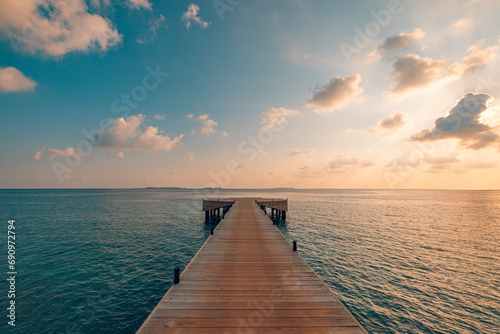 Beautiful seascape long jetty pier at sunset. Minimal sea sky, calm water surface and reflections. Colorful peaceful sunrise tones orange, gold, blue. Tranquil relaxing panoramic inspire meditation 