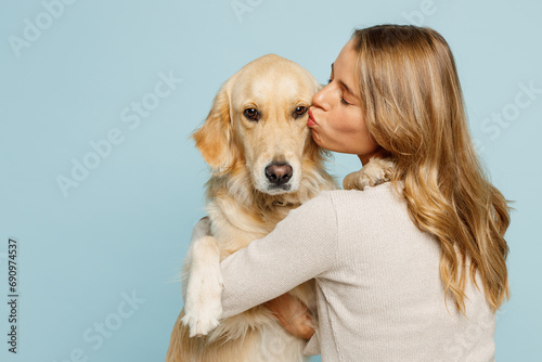 Back rear view young owner blonde woman with her best friend retriever dog wear casual clothes hug embrace kiss dog isolated on plain pastel light blue background studio. Take care about pet concept.
