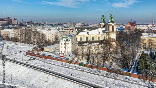 Krakow, Poland. Skalka, St. Stanislaus church na Skałce and Paulinite monastery in snow. Aerial panning video in winter. People walking on boulevard and promenade. Old town and Wawel in the background photo