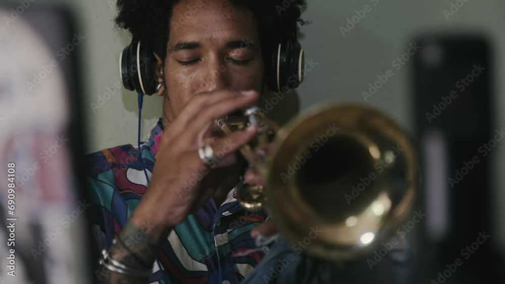 Inspired jazz musician playing trumpet recording song with microphone