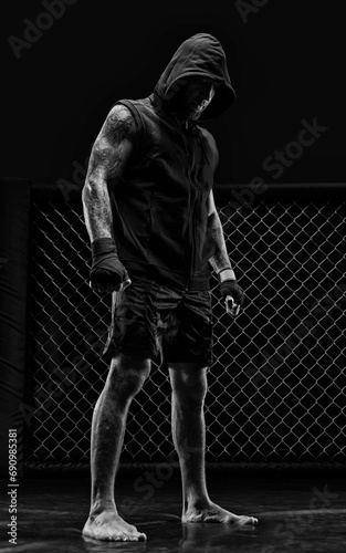 The dramatic black white image of the MMA fighter. Photography in a real octagon. Brutal fighter