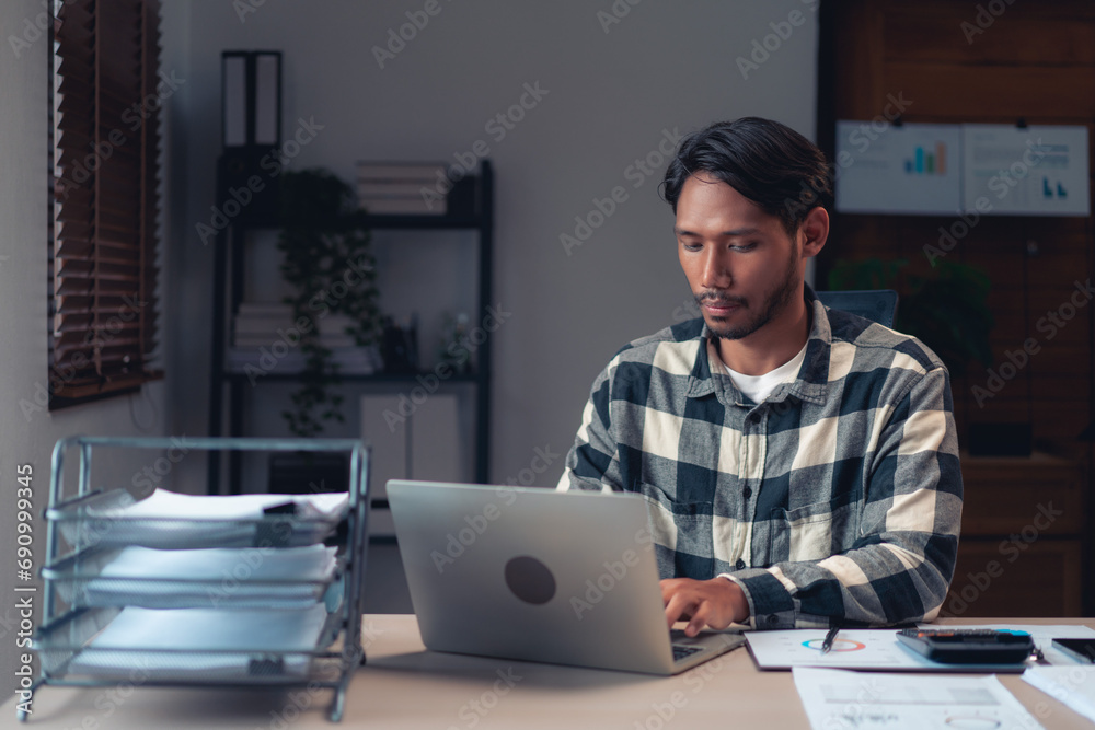 Businessman typing data on laptop while working to analysis financial and accounting of business Businessman typing data on laptop while working to analysis financial and accounting of business