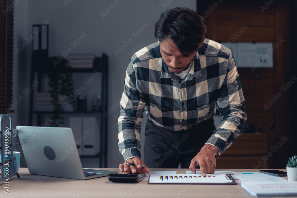 Businessman using calculator to checking financial and accounting report of business in office Businessman using calculator to checking financial and accounting report of business in office