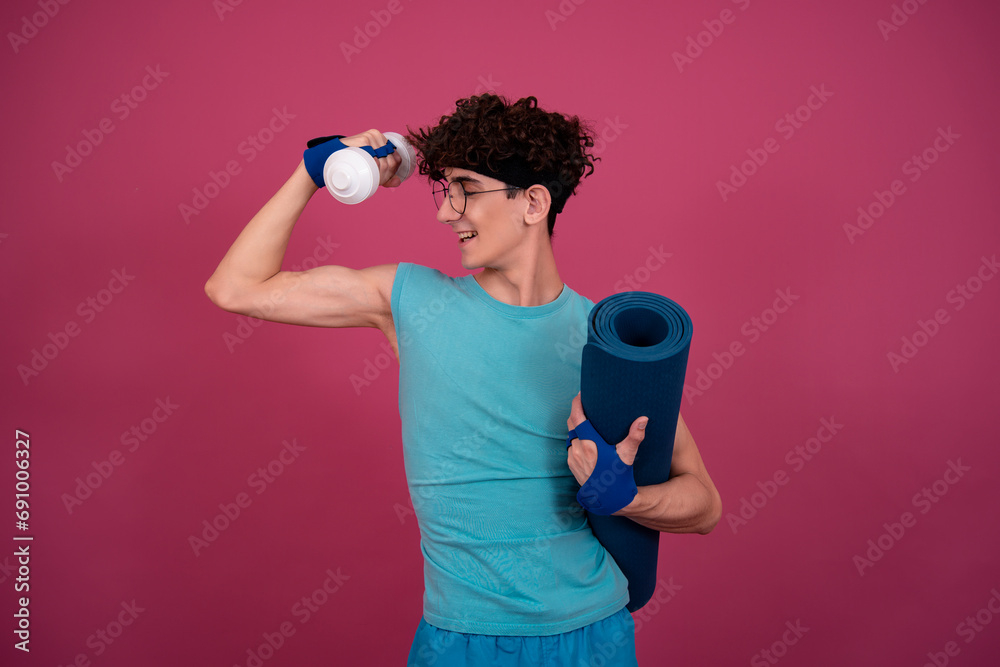 Obraz premium Retro style. Funny curly guy doing aerobics in the style of the 80s. Pink background.
