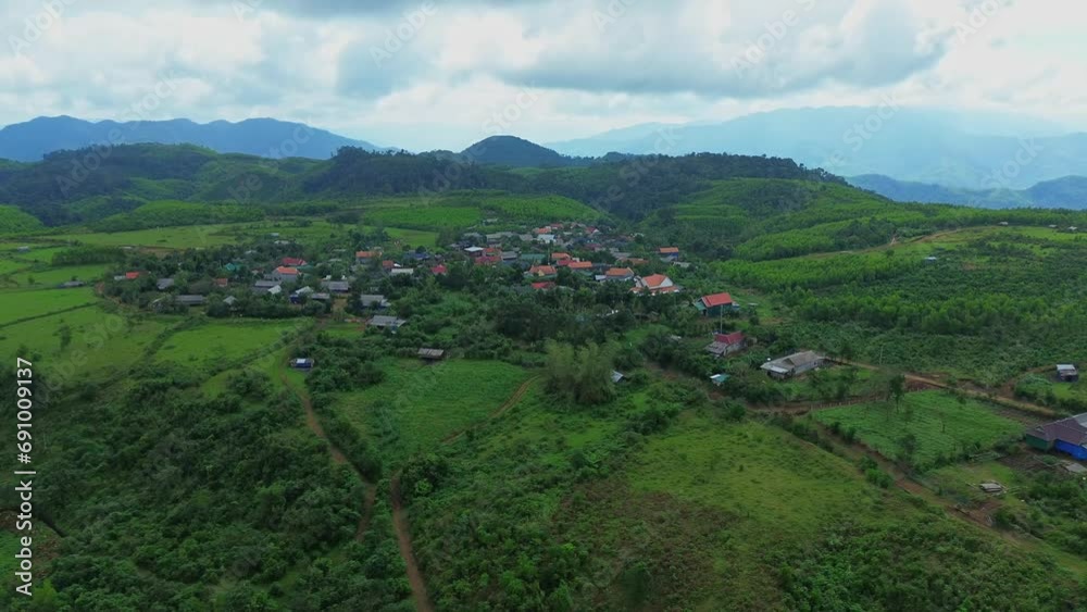 Small village on a small steppe surrounded by mountains and forests in Vietnam, aerial view from drone. Small village on a small steppe surrounded by mountains and forests in Vietnam, aerial view from drone.
